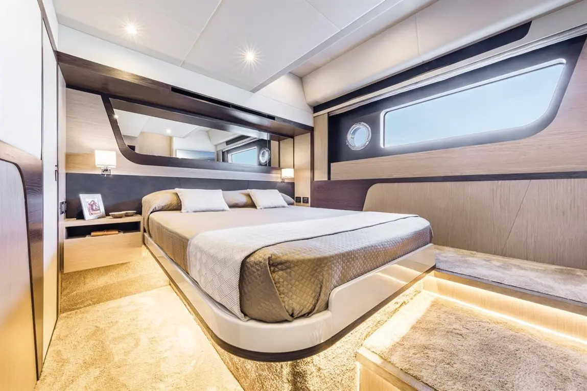 Modern yacht bedroom featuring a double bed, soft lighting, mirrors, and large windows with a view. Elegant and spacious design.